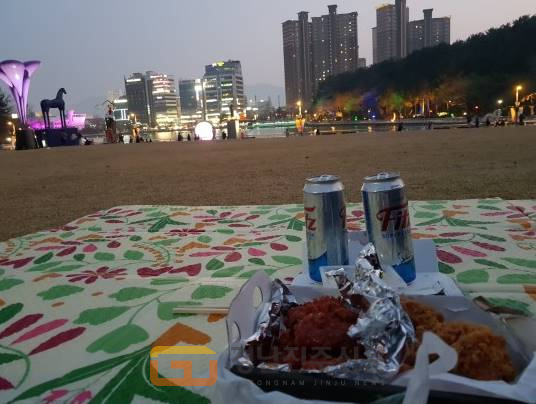 (독자제보) 경남진주신문 한 독자가 창원시 용지호수 공원에서 늦은 오후 돗자리 위에서 치맥(치킨과 맥주)으로 여유를 만끽하고 있다.